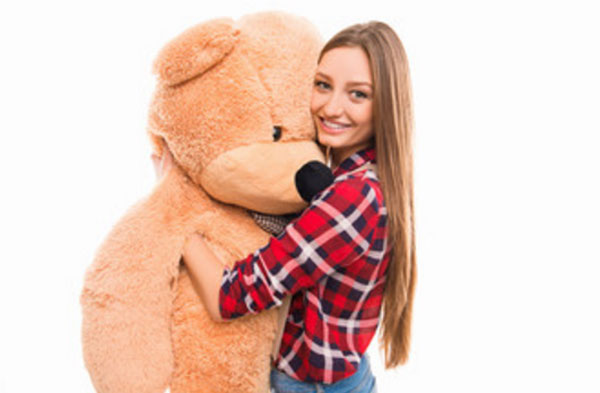 Девушка с большим плюшевым медведем в руках
