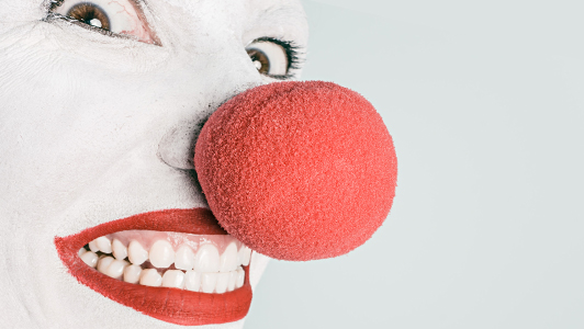 Clown with huge red nose grinning