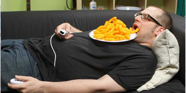 Безработный мужчина лежит на диване с едой