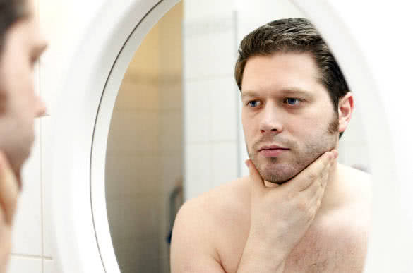 Man looks at his beard and thought about shaving